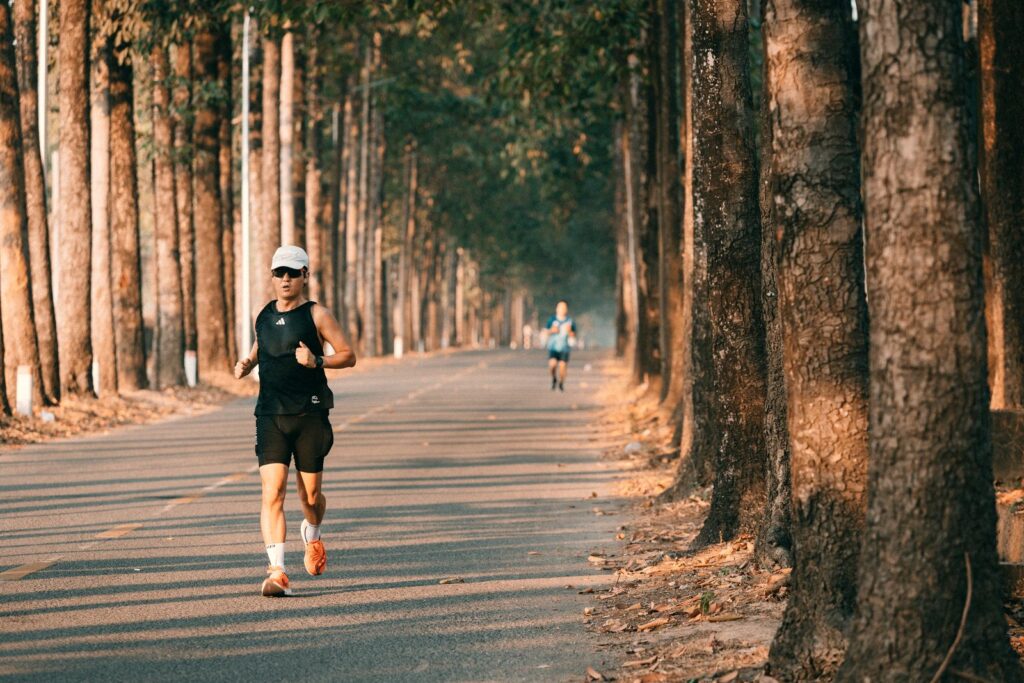 Runner on a tree lined road in the early morning